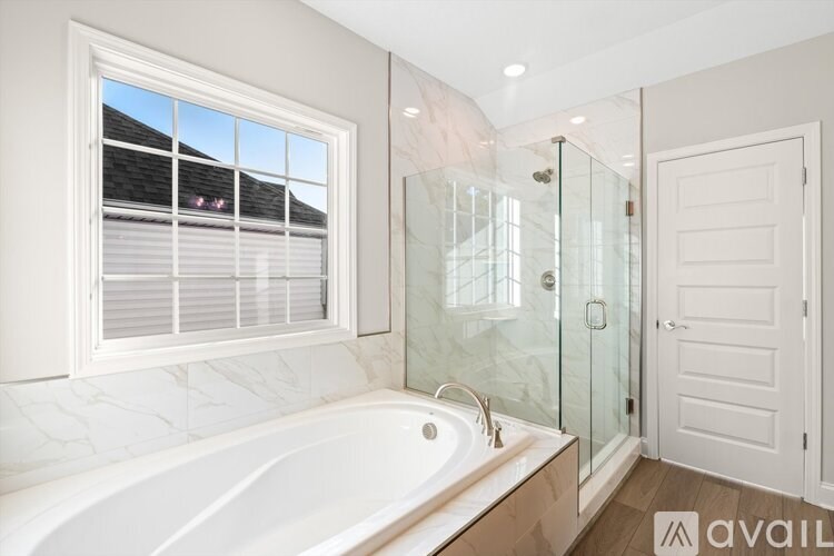 A bathroom with a large tub and a walk-in shower.