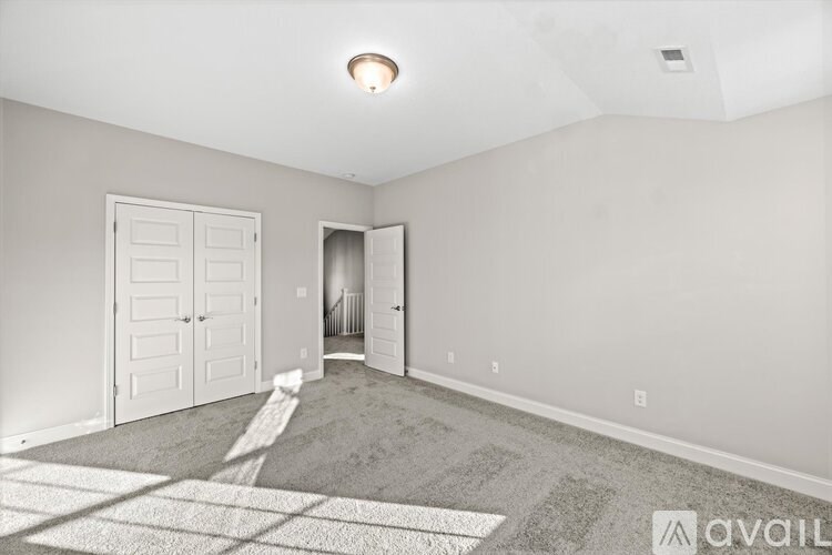 A room with a rug on the floor and a door on the left side.