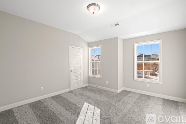 A room with a carpeted floor and a window showing a view of a building outside.