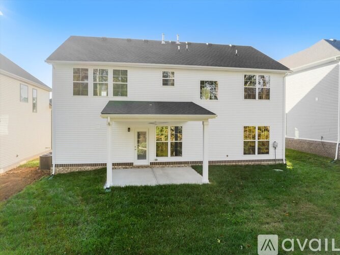 A white house with a black roof and a covered porch.
