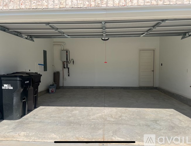 A large, empty garage with a concrete floor and white walls.