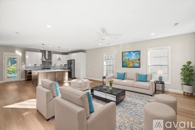 A living room with a couch, chairs, and a coffee table.