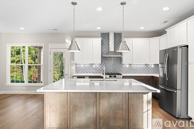 A modern kitchen with a large island and stainless steel appliances.