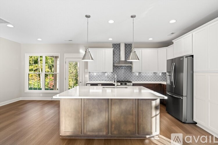 A modern kitchen with a wooden island and stainless steel appliances.