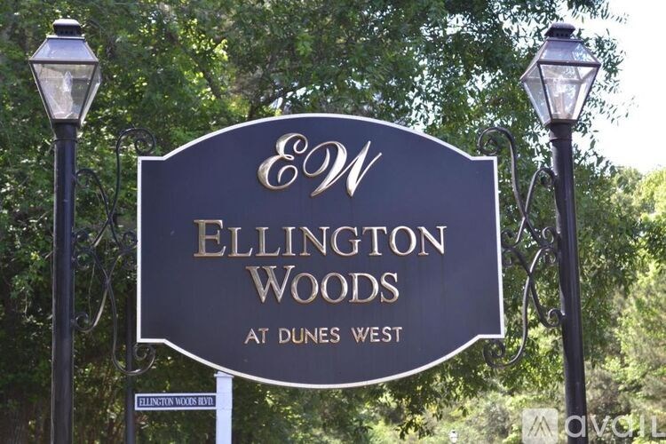 A sign for Ellington Woods at Dunes West is displayed on a post.
