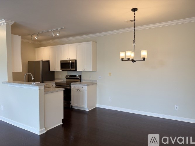 A kitchen with white cabinets and a black fridge.