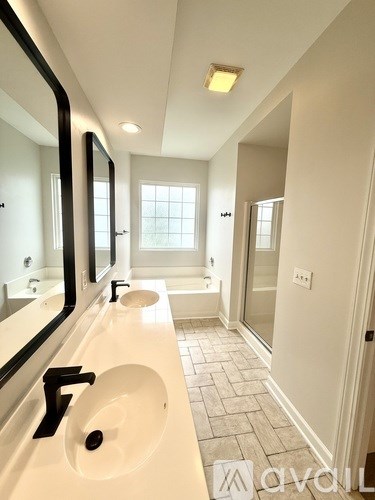 A bathroom with a white sink and a large mirror.