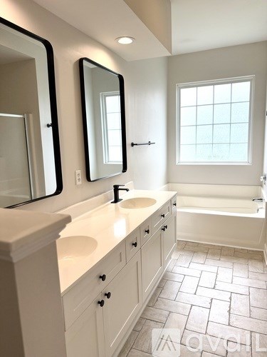 A white bathroom with a large mirror and a window.