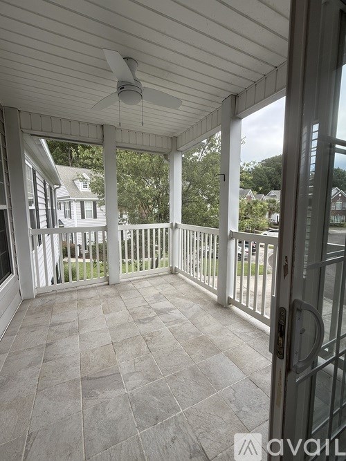 A patio with a fan and sliding glass doors.