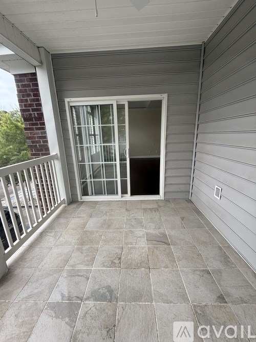 A balcony with a glass door and a tiled floor.