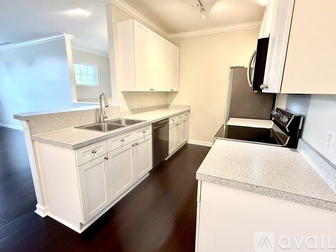 A kitchen with white cabinets and a granite countertop.
