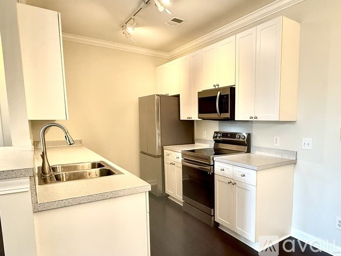 A kitchen with white cabinets and stainless steel appliances.