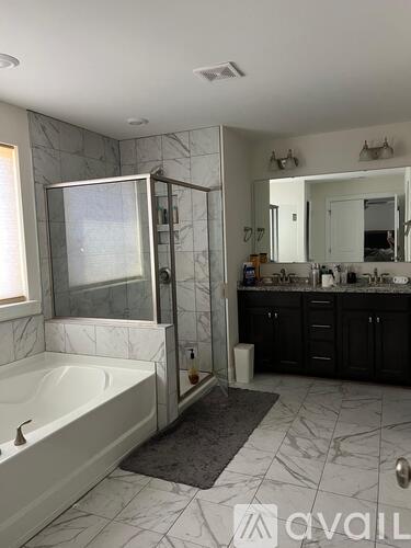 A bathroom with a marble floor and a white bathtub.