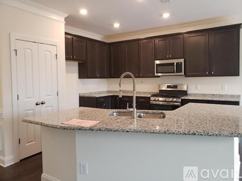 A kitchen with brown cabinets and a granite countertop.