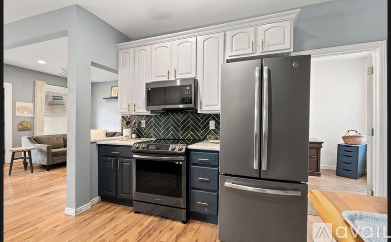 A modern kitchen with a black fridge and stove.