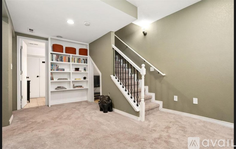 A room with a staircase and a bookshelf.
