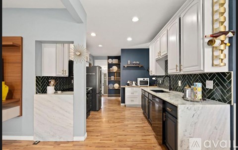 A modern kitchen with dark wood cabinets and a marble countertop.