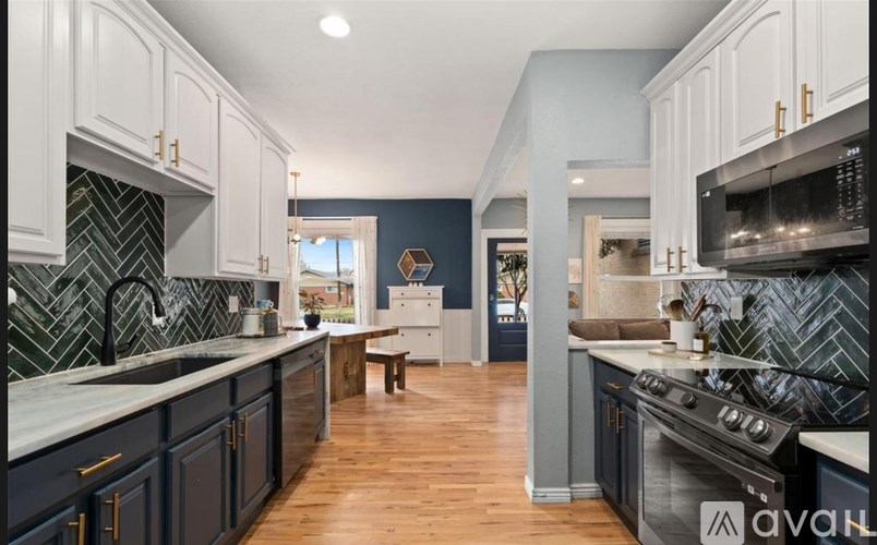 A kitchen with dark blue cabinets and a wooden floor.