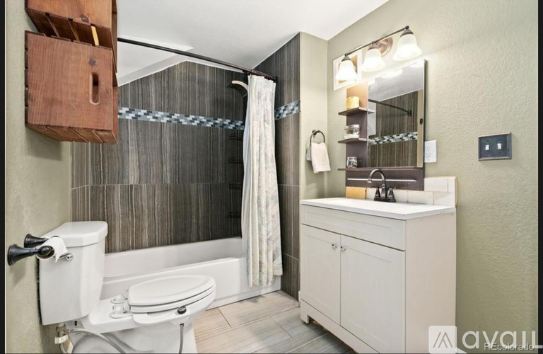 A bathroom with a toilet, sink, and shower.
