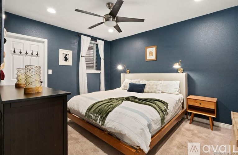 A bedroom with a bed, nightstand, and a ceiling fan.