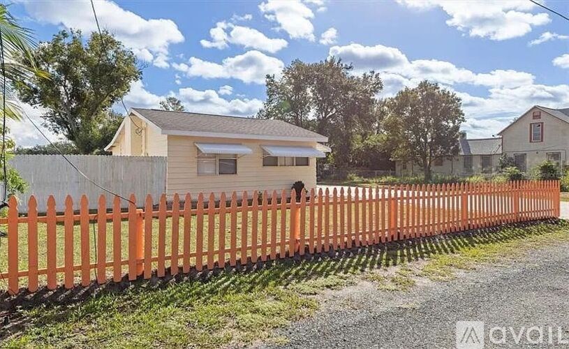 A house with a wooden fence in front of it.