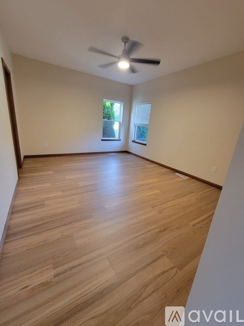 A room with wooden flooring and a ceiling fan.