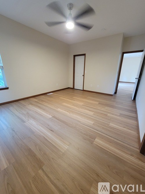 A room with wooden flooring and a ceiling fan.