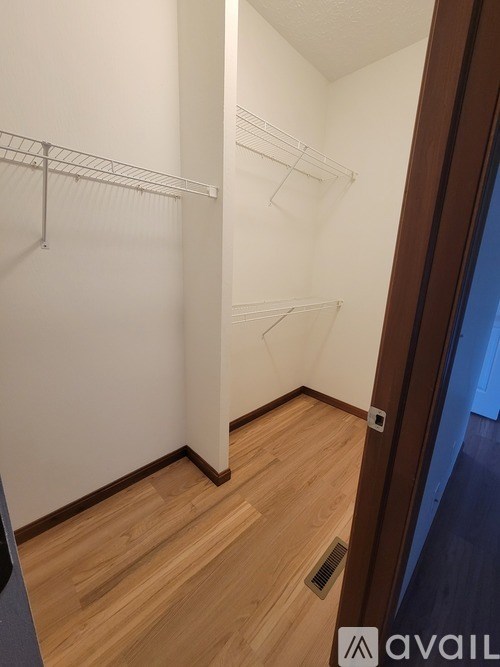 A room with a white wall and a wooden floor.