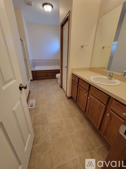 A bathroom with a sink, mirror, and bathtub.