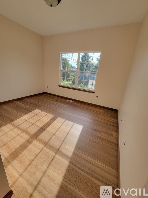 A room with wooden flooring and a window.