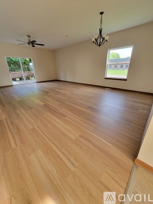 A room with wooden flooring and a ceiling fan.