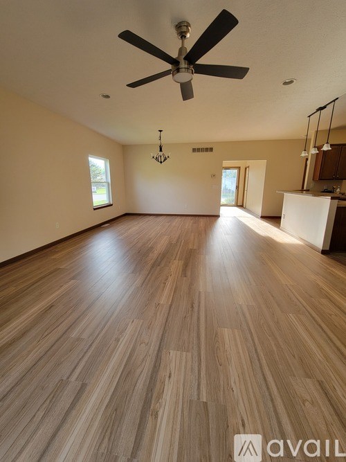 A room with wooden flooring and a ceiling fan.