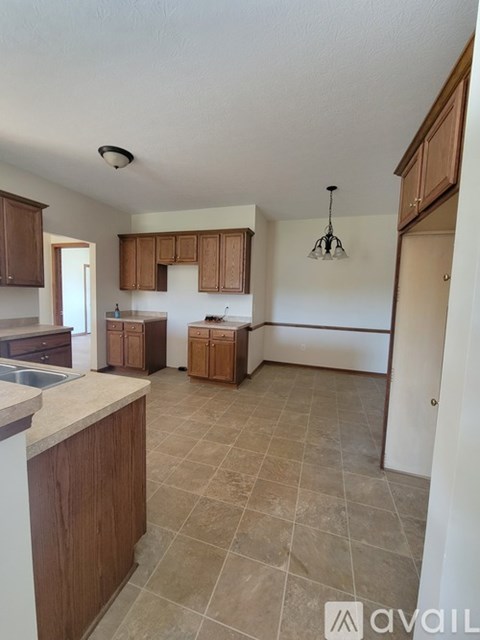 A kitchen with brown cabinets and a tiled floor.