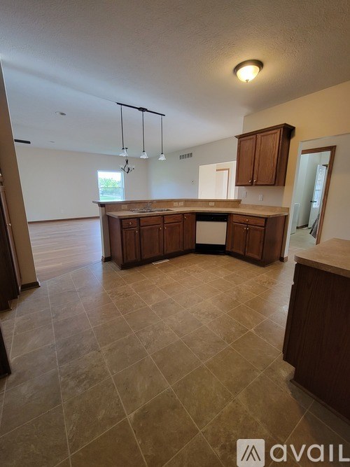 A kitchen with brown cabinets and a tiled floor.