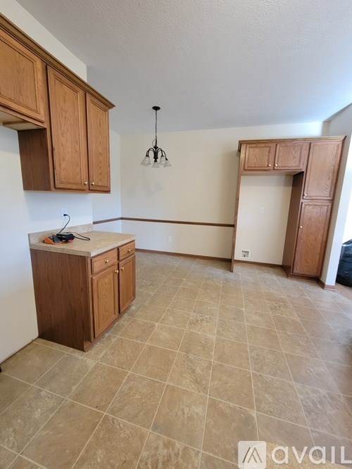 A kitchen with wooden cabinets and a tiled floor.