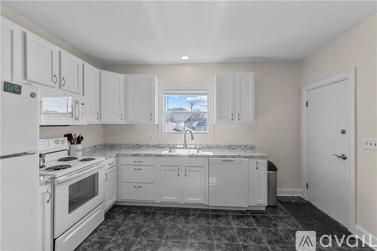 A kitchen with white appliances and cabinets.