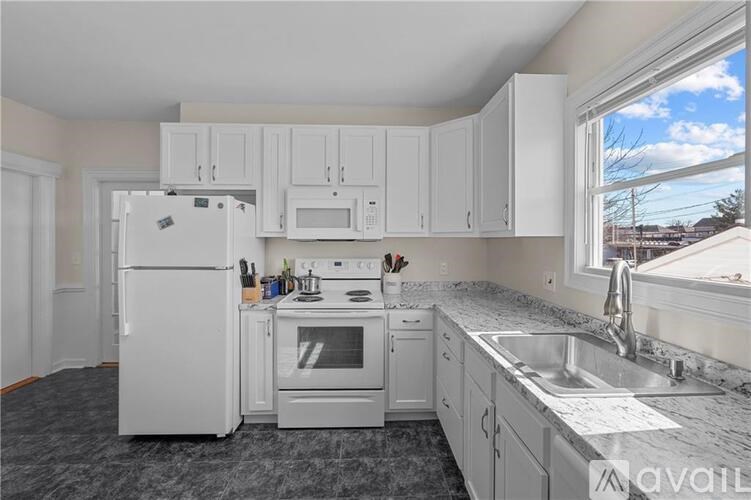 A kitchen with white appliances and cabinets.