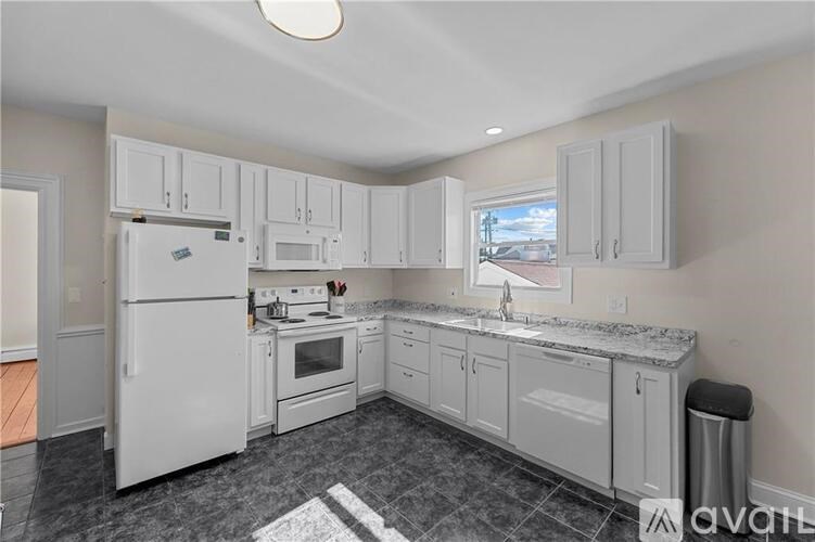 A kitchen with white appliances and cabinets.