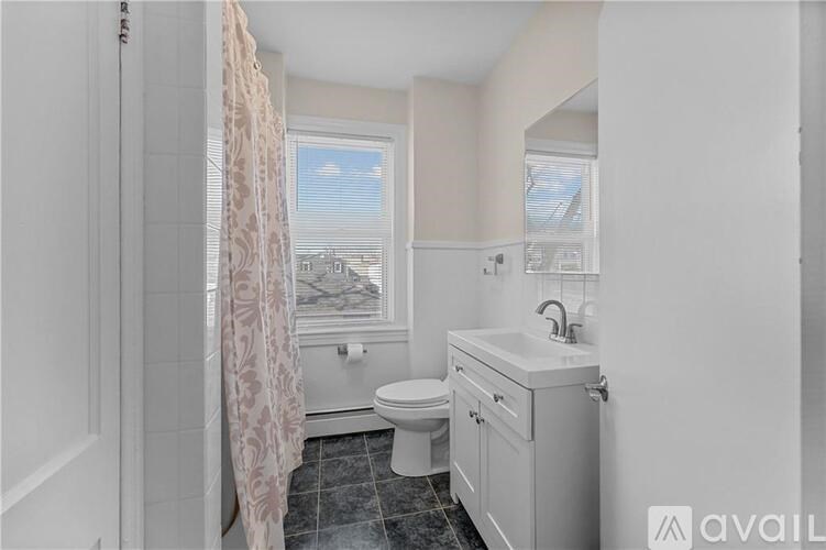 A bathroom with a toilet, sink, and shower.