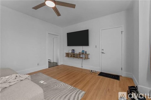 A living room with a grey sofa and a wooden floor.