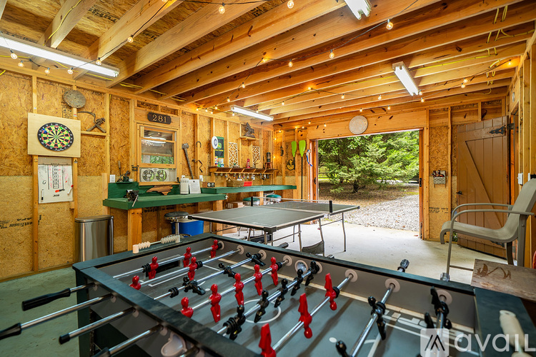 A game room with a foosball table and a dartboard.