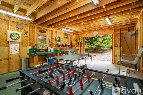 A game room with a foosball table and a dartboard.
