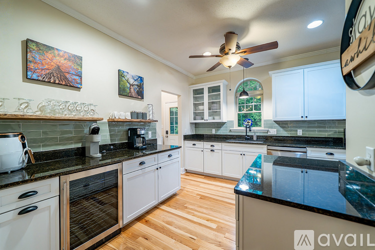 A kitchen with a black counter top and white cabinets.