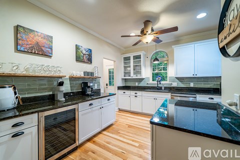 A kitchen with a black counter top and white cabinets.