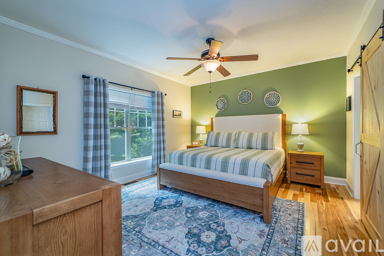 A bedroom with a bed, dresser, and window.