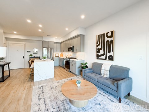 A modern living room with a grey couch and a wooden coffee table.