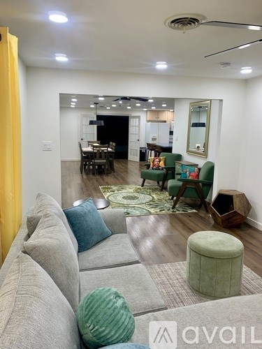 A living room with a grey couch and a green ottoman.