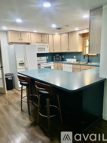 A kitchen with a bar area and a refrigerator.