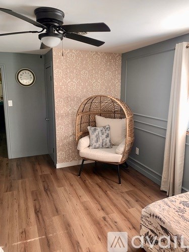 A room with a hanging chair and a ceiling fan.