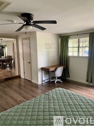 A room with a bed, desk, and chair.